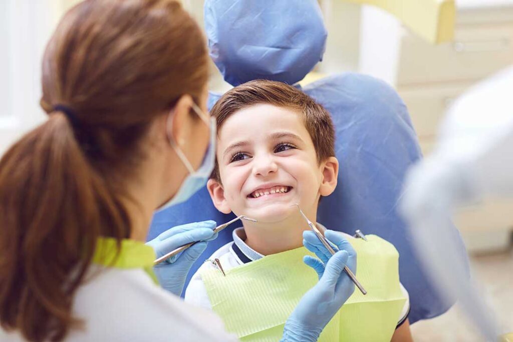A middle-aged person looking at stained teeth in a bathroom mirror, holding a toothbrush.